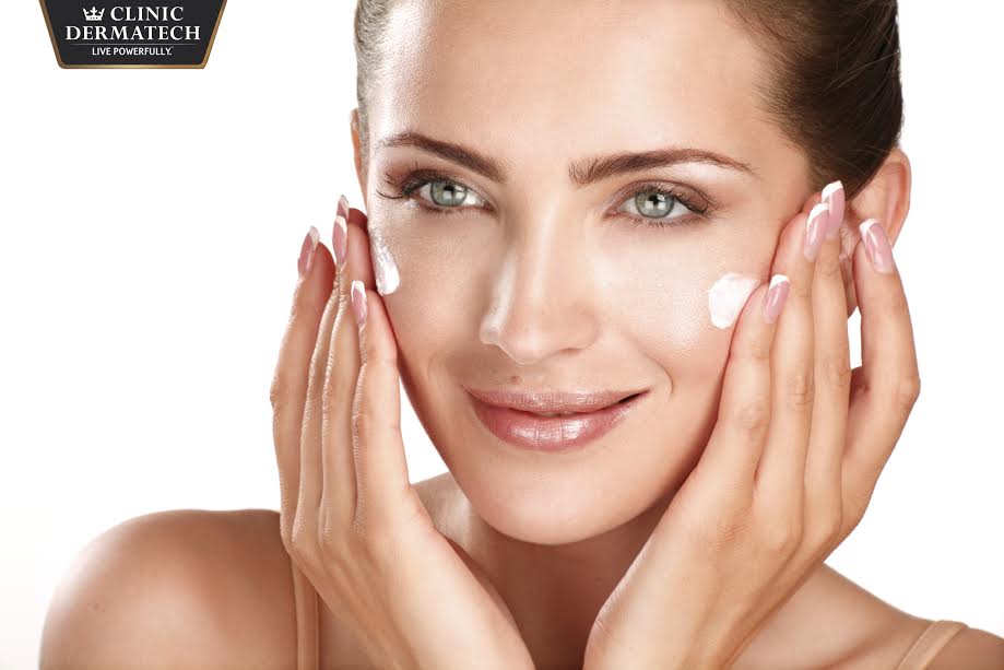 beautiful model applying cosmetic cream treatmen on her face